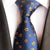 Blauwe stropdas met oranje bloemen en witte stippen